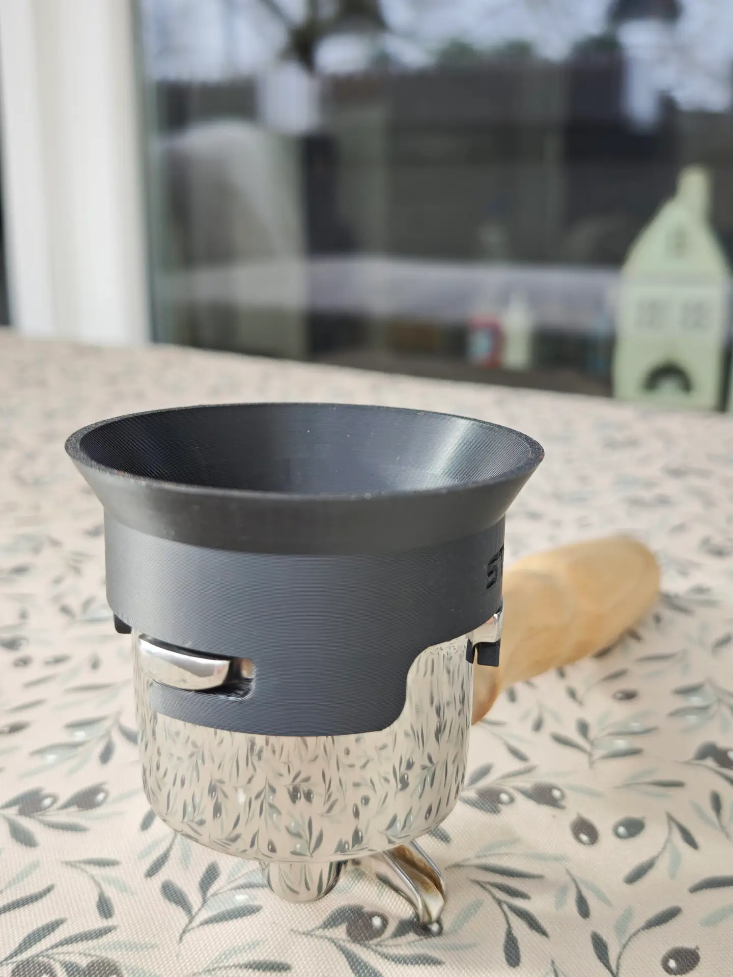 The dosing funnel sits on the portafilter via bayonet mount