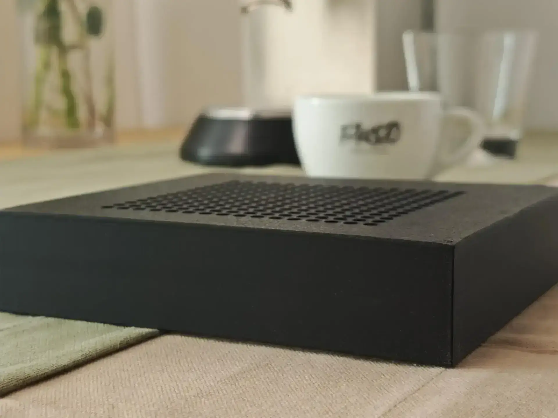 The flat Slim drip tray on the table, next to it an espresso cup for size comparison