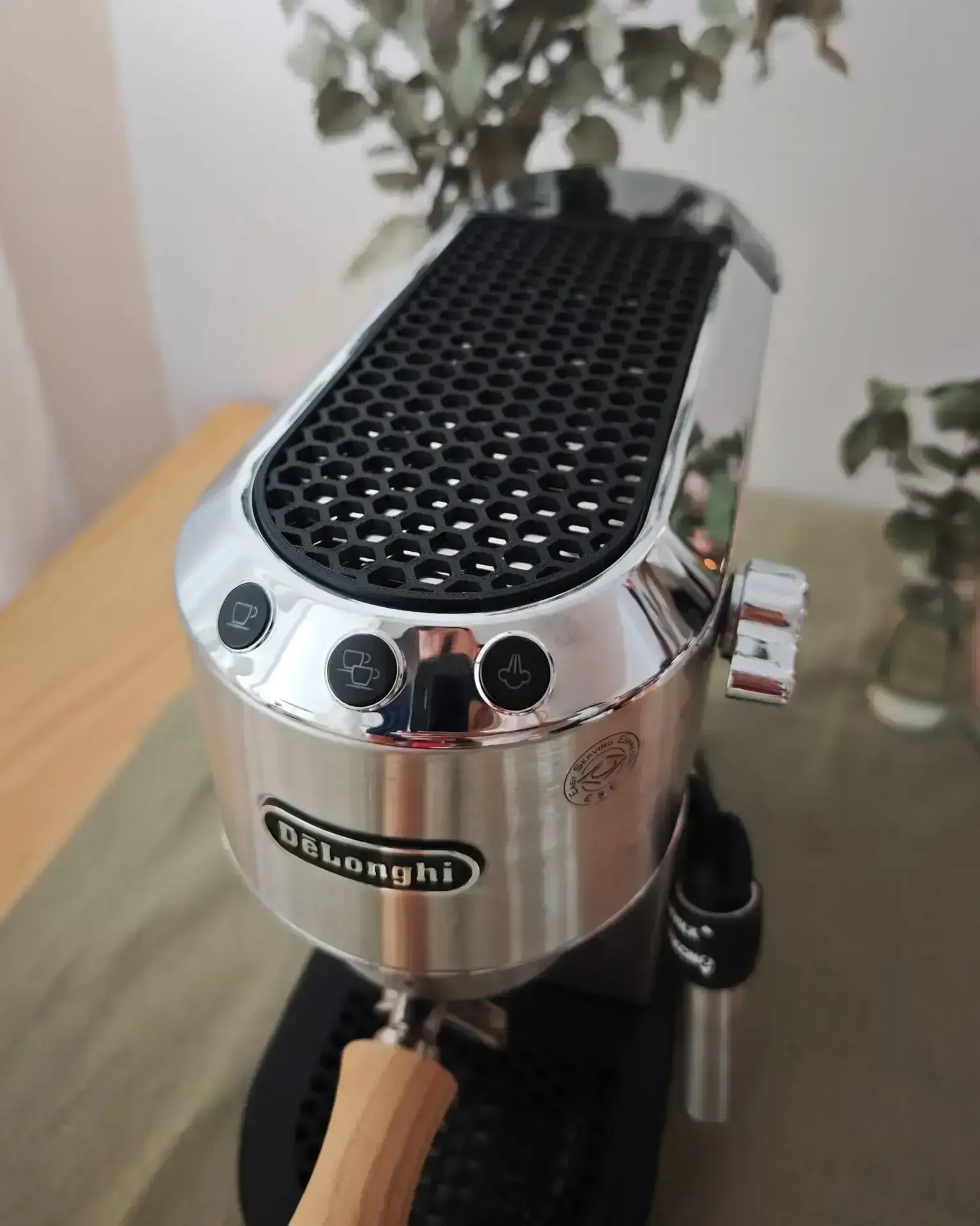 Honeycomb Design cup rest on the top plate of the De'Longhi Dedica, matte black honeycomb structure