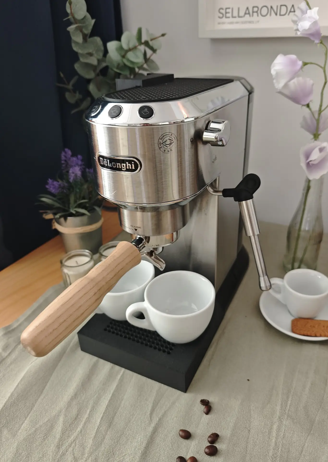 De'Longhi Dedica con la bandeja Livanto, dos tazas y flores sobre la mesa