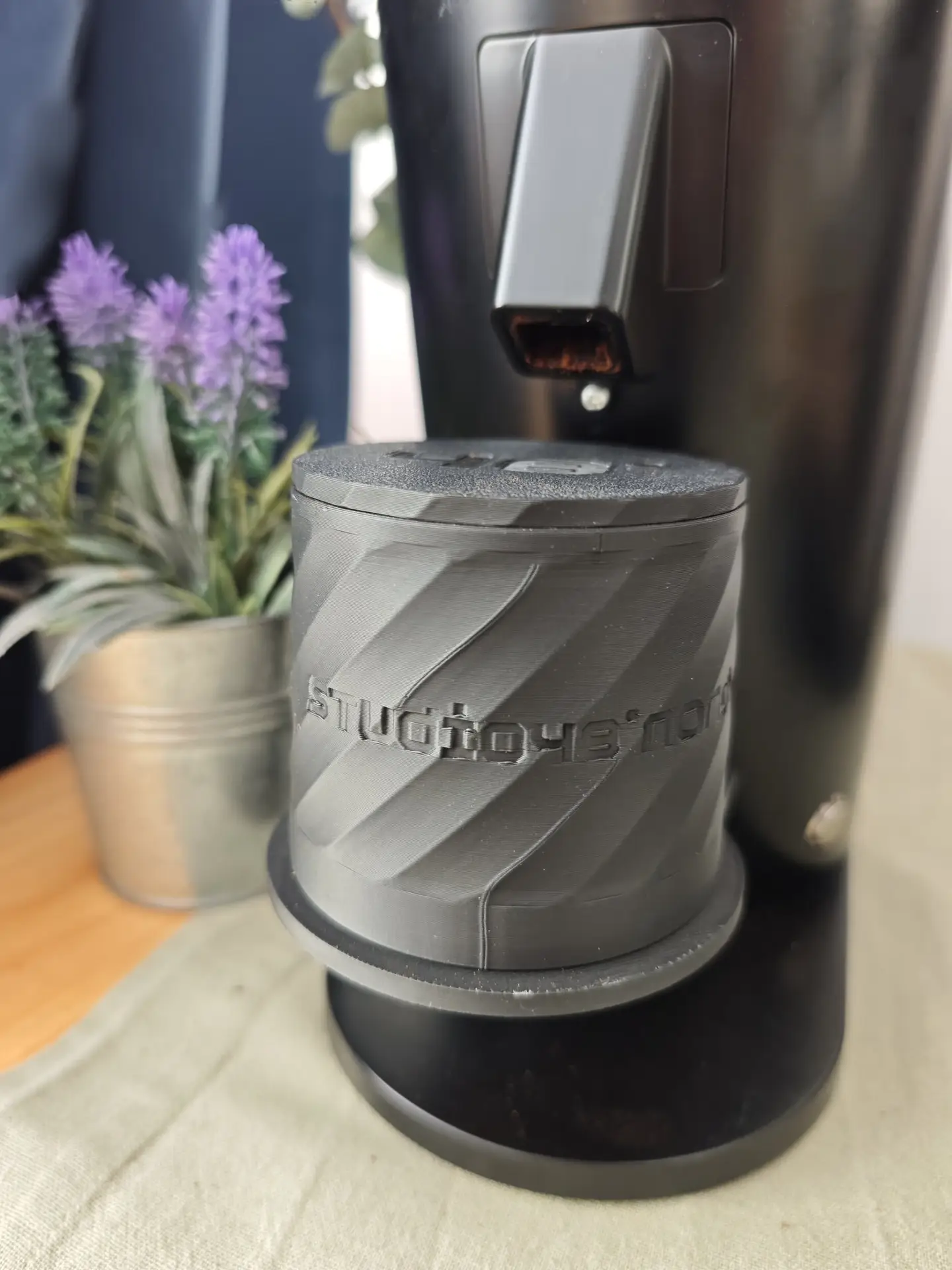 Blindshaker 51 mm mit gedrehtem Rillenmuster, mattschwarz, neben einer Pflanze